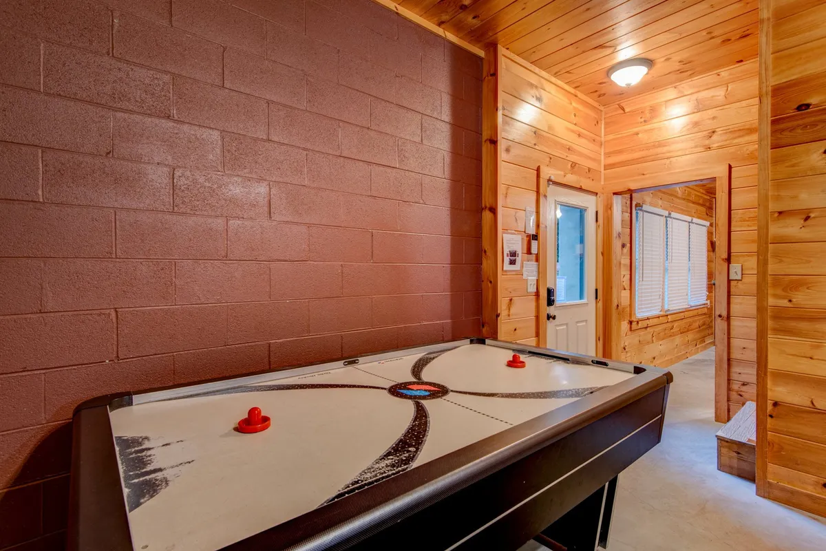 This image zooms in on the air hockey table, a key feature of the game room. The table is ready for play, set in a bright, fun, and inviting portion of the space.